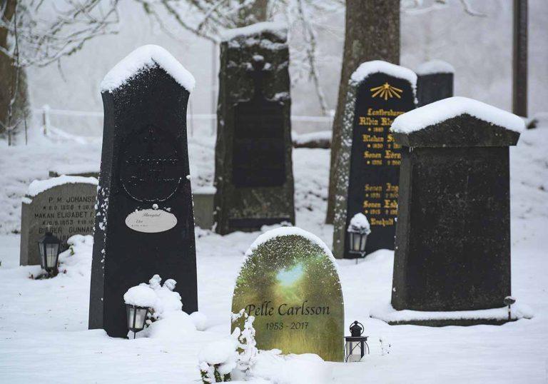 Gravsten i glas i en kyrkogård vintertid