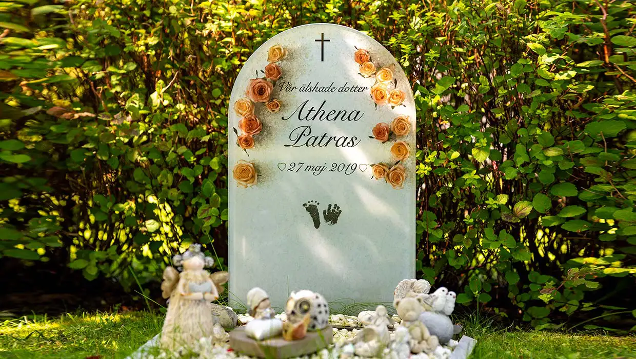 Gravsten med bildmotiv monterad på en begravningsplats